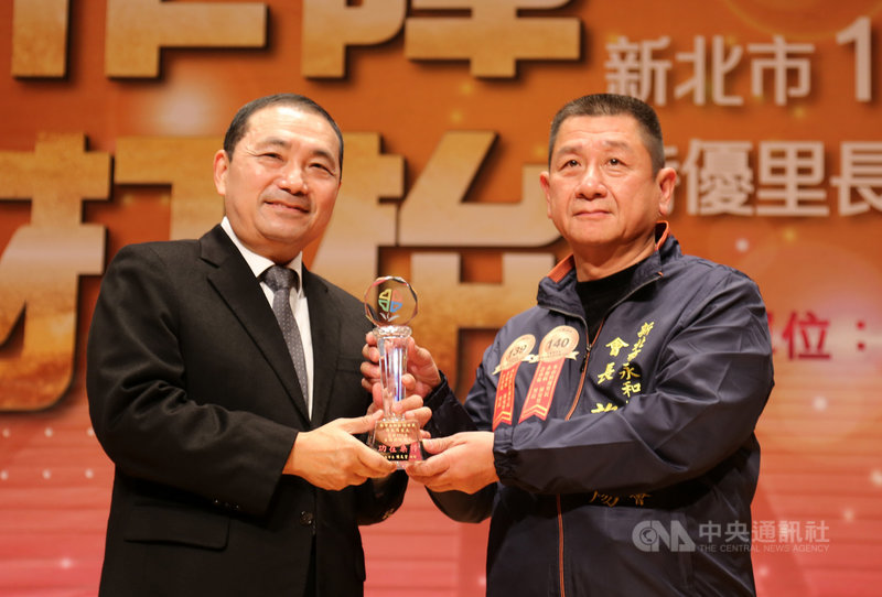 新北市民政局27日舉行「110年特優里長及績優民政人員表揚大會」,由市長侯友宜(左)表揚特優里長及績優民政人員,其中永和區保安里長許承煬(右)今年更同時獲頒內政部特優里長殊榮。(新北市府提供)中央社記者黃旭昇新北市傳真 110年11月27日