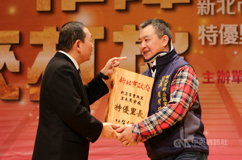 新北市長侯友宜(左)27日表揚特優里長及績優民政人員,新店區寶興里長周宥竣(右)也獲市府表揚,開心從侯友宜手中接下獎牌。(新北市政府提供)中央社記者黃旭昇新北市傳真 110年11月27日