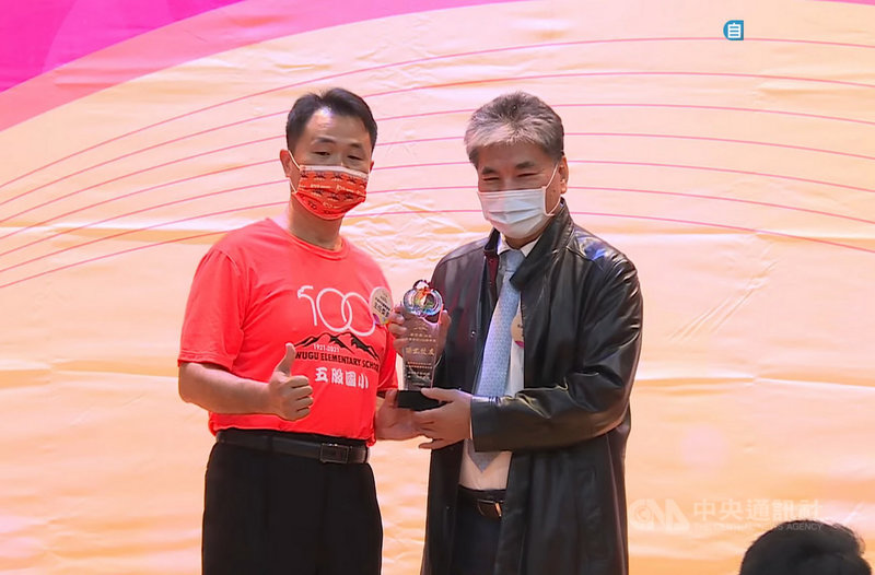 新北市五股國小27日慶祝百年校慶,前內政部長李鴻源(右)的母親李子美會中獲頒傑出校友,由李鴻源代表接受。(五股國小提供)中央社記者黃旭昇新北市傳真 110年11月27日