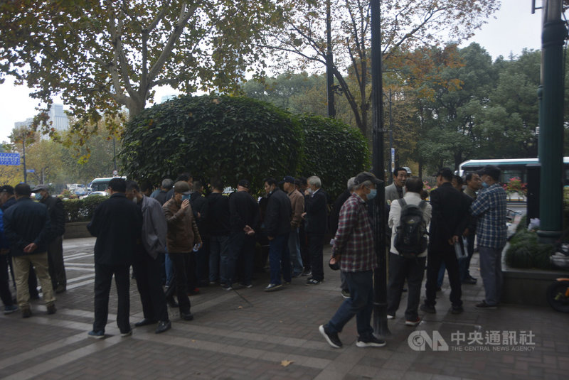 每个周日下午，在上海人民广场旁边广东路的都市总部大楼外，会出现一大群人聚集热烈讨论有关于股票的资讯。中央社记者吴柏纬上海摄  110年11月28日