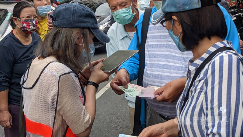 高雄商圈夜市券29日起進行第2波發放,高雄市政府經發局表示,第2波換發將有工作人員先隨排隊隊伍驗、拍身分證與振興券,待各場表定時間起發號碼牌,民眾再憑號碼牌及振興券換發夜市券。中央社記者曾以寧攝 110年11月29日