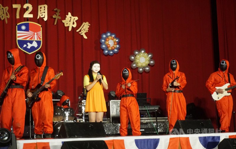 金門防衛指揮部72週年部慶暨社團成果發表會30日下午登場,擎天樂團以時下正夯的韓劇「魷魚遊戲」裝扮出場,令人會心一笑。中央社記者黃慧敏攝 110年11月30日