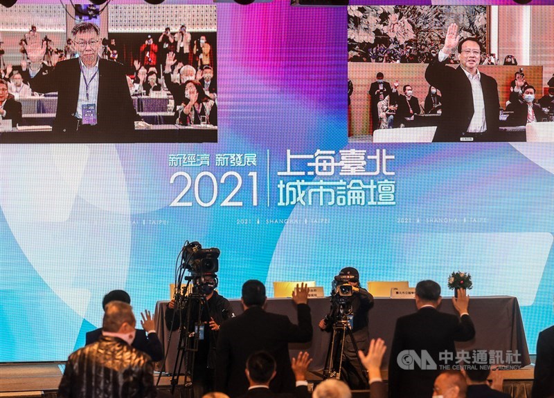 2021上海台北城市論壇於1日下午登場,採視訊方式進行,台北市長柯文哲(螢幕左)、上海市長龔正(螢幕右)透過視訊同台,揮手向眾人致意。中央社記者鄭清元攝 110年12月1日