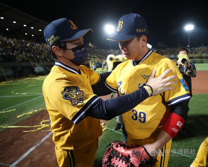 中華職棒總冠軍賽第4戰1日在台南棒球場舉行,中信兄弟終場以5比0、4連勝擊敗統一獅,睽違11年順利拋下黃色封王彩帶,拿下隊史第8座總冠軍。賽後兄弟總教練林威助(左)擁抱詹子賢(右)。中央社記者張新偉攝 110年12月1日