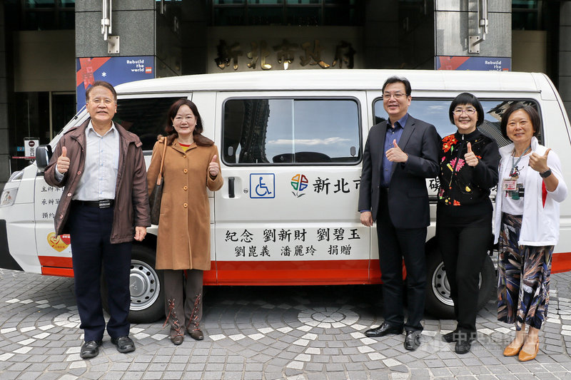 德明財經科技大學資訊管理系副教授劉崑義(左)與妻子潘麗玲(左2)將原來留給孩子的留學經費,轉為購置1輛復康巴士,2日捐贈新北市政府,藉以感念父母養育之恩。(新北市社會局提供)中央社記者黃旭昇新北市傳真 110年12月2日
