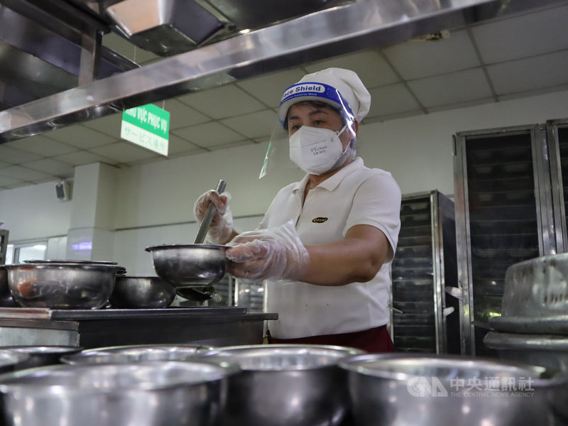 越南西貢高科技園區內一家企業的餐廚人員戴著口罩、透明面罩正在準備員工餐。中央社記者陳家倫胡志明市攝 110年12月3日