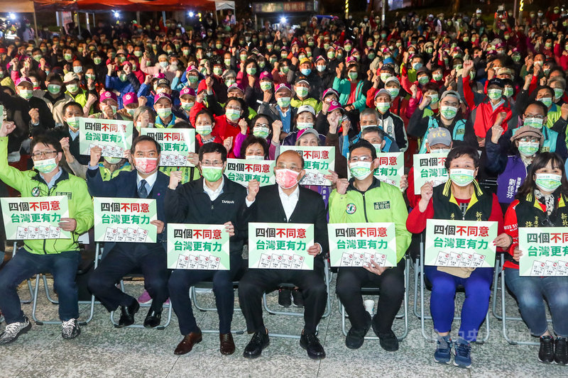 民進黨新北市議員黃俊哲(前右3)3日晚間在板橋區舉辦公投說明會,行政院長蘇貞昌(前中)與民進黨立委羅致政(前左3)及行政院政務委員羅秉成(前左2)等人出席,眾人手持看板齊呼口號表達立場。中央社記者王騰毅攝 110年12月3日