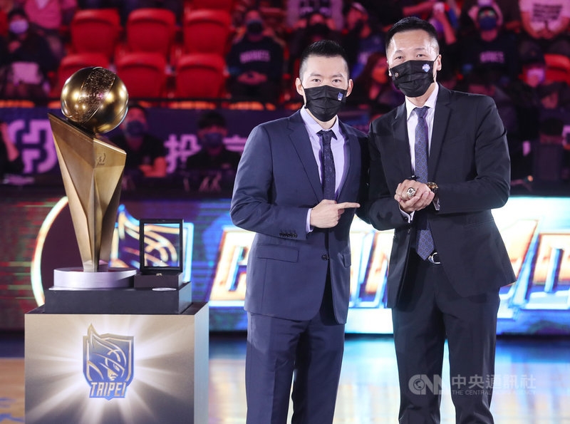 台灣職籃聯盟P. LEAGUE+(簡稱PLG)4日在台北和平籃球館進行新球季開幕戰,上屆冠軍台北富邦勇士隊賽前舉辦冠軍戒指頒發儀式,由領隊蔡承儒(左)逐一頒發冠軍戒給總教練許晉哲(右)與球員。中央社記者張新偉攝 110年12月4日