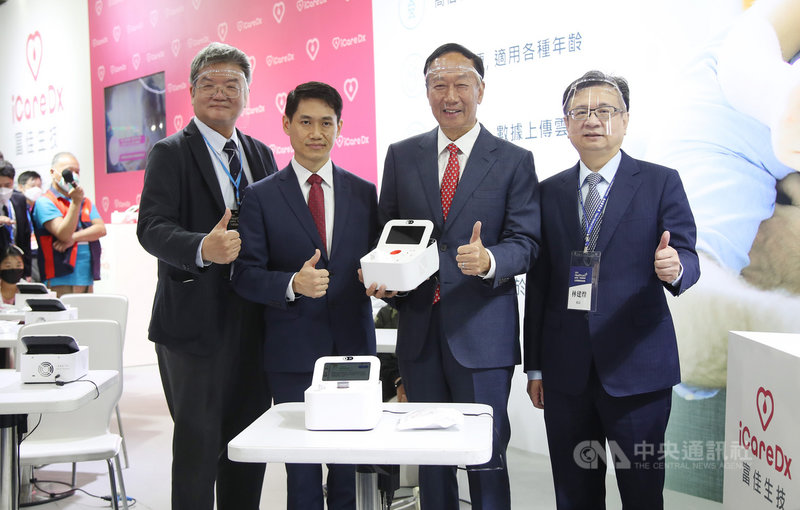 鴻海創辦人郭台銘(右2)4日到台北南港展覽館一館參觀2021台灣醫療科技展富佳生技展位,並示範富佳生技所研發的PSS‐1s核酸檢測分析儀及試劑。中央社記者張新偉攝 110年12月4日