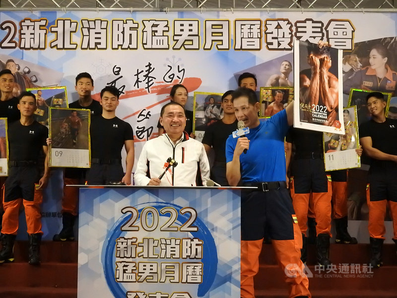 新北市政府6日舉辦「新北消防形象(猛男)月曆」發表會,市長侯友宜(前左)簽名的月曆提供拍賣,經激烈競標,最後以新台幣30萬元的高價售出。中央社記者王鴻國攝 110年12月6日