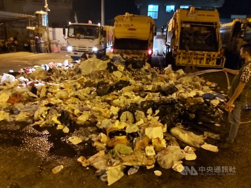 高雄市鹽埕區清潔隊資源回收車6日將資收物載回停車場時,車輛突然冒出白煙,現場人員將回收物卸出灑水降溫,發現回收物品內混有瓦斯罐。(高市環保局提供)中央社記者洪學廣傳真 110年12月7日