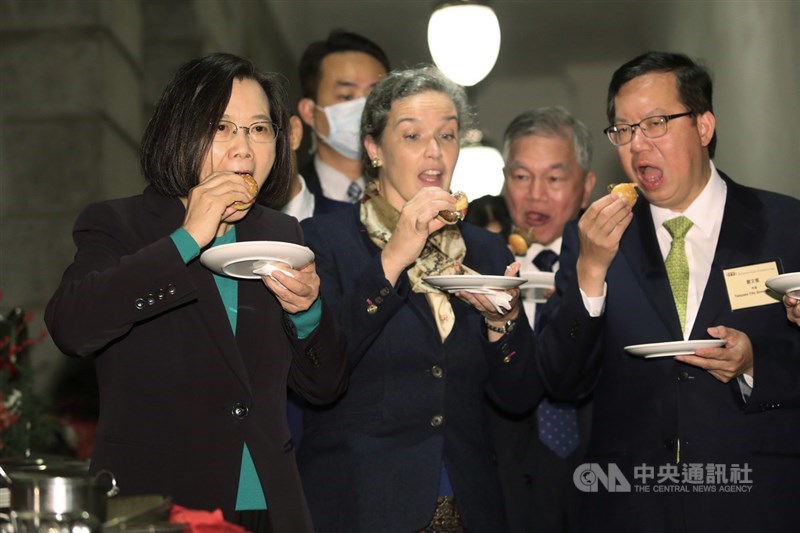 總統蔡英文(左)8日晚間出席在台北賓館舉辦的「台灣美國商會70週年慶祝活動」,與美國在台協會(AIT)處長孫曉雅(前中)、桃園市長鄭文燦(右)等人一同品嘗小漢堡等精緻美食。中央社記者吳家昇攝 110年12月8日