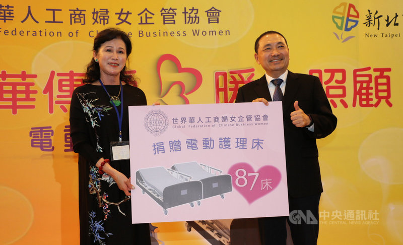 世界華人工商婦女企管協會總會長陳阡蕙(左)8日代表捐贈87床電動護理床給新北市社福機構,新北市長侯友宜(右)代表受贈。(新北市社會局提供)中央社記者黃旭昇新北市傳真 110年12月8日