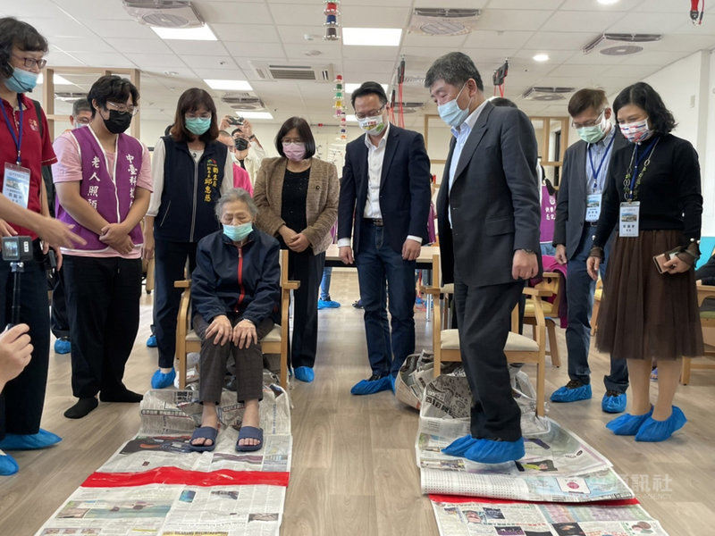 立法院社福及衛生環境委員會9日到台中市考察長照及醫療業務,衛福部長陳時中(前右)在中台科大參觀長照機構時,親自體驗腳踏報紙拔河的復健活動。中央社記者郝雪卿攝 110年12月9日