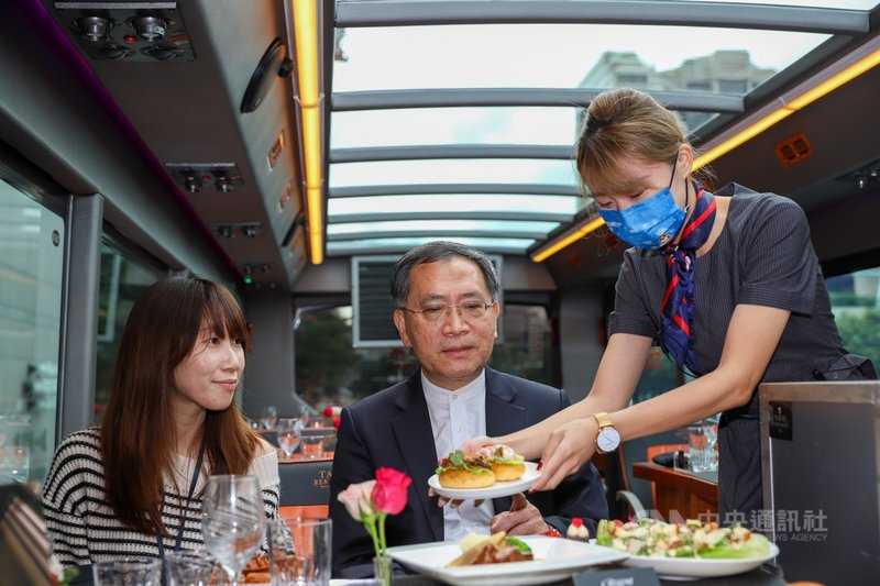 台北市政府觀傳局推出雙層餐車,並與晶華酒店合作推出下午茶與晚餐套裝行程,讓旅客可在車上邊欣賞台北城風光邊吃美食,台北市副市長蔡炳坤(中)9日出席記者會宣傳。中央社實習記者蕭宇軒攝 110年12月9日