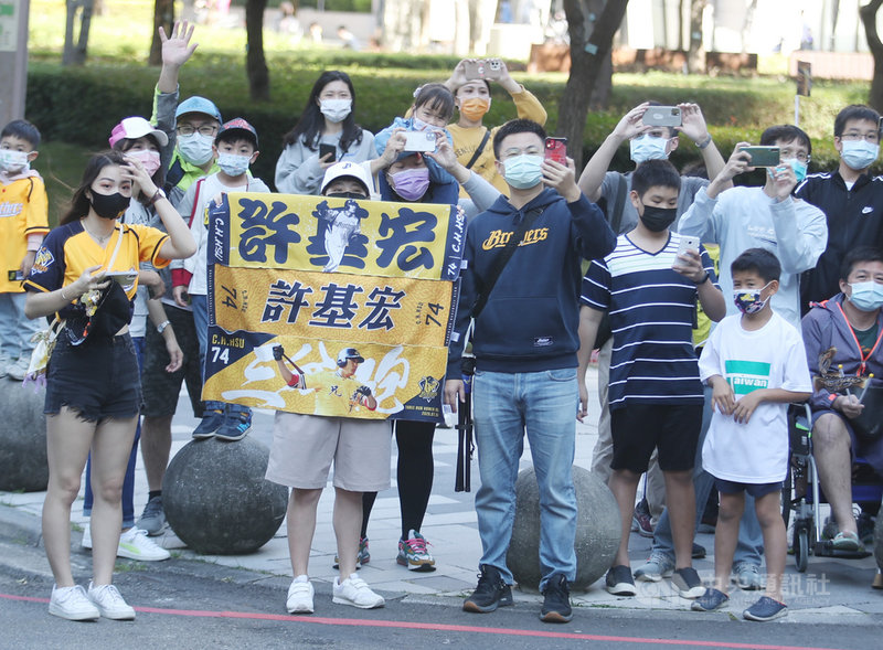 中職中信兄弟隊拿下睽違11年的總冠軍,封王遊行車隊12日從台中市政府前出發,許多球迷在定點等待球員車隊到來。中央社記者張新偉攝 110年12月12日