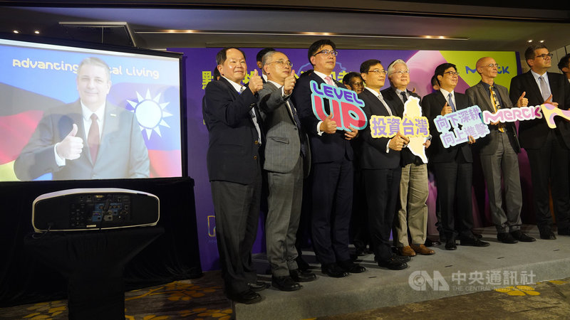 高雄市長陳其邁(右3)14日北上台北出席德商默克集團啟動在台最大投資案記者會,與台灣默克集團董事長李俊隆(左3)、科技部長吳政忠(右4)等人合影,默克集團電子科技事業體執行長貝克曼(Kai Beckmann)(左側螢幕)透過視訊連線共襄盛舉。中央社記者徐肇昌攝 110年12月14日