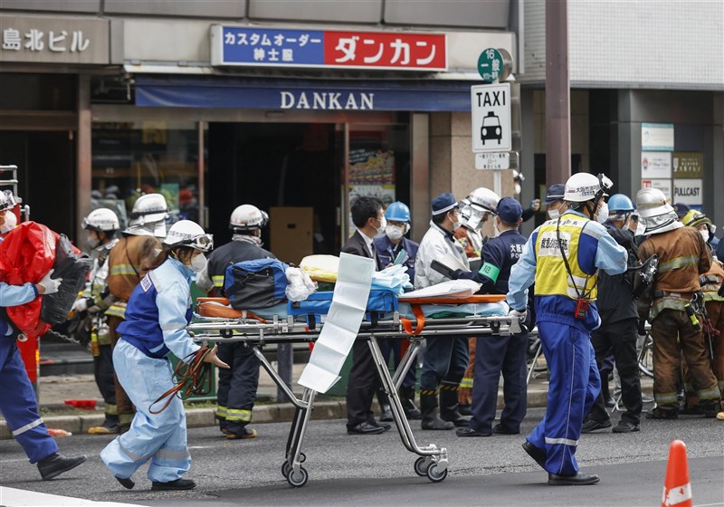 2021年12月，大阪市一間診所遭人縱火，釀成26人死亡慘劇。圖為消防人員抬著擔架緊急搶救。（共同社）