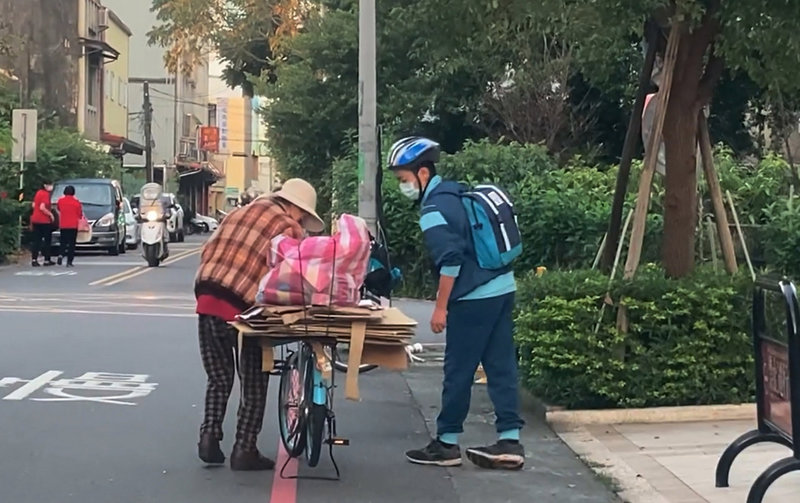 宜蘭國中學生熊建鈞（右）24日上學時，協助一名拾荒婦（左）把從腳踏車後座掉落廢紙歸回原位，還向她點頭致意才離開，獲得外界讚許。（民眾黃賜福提供）中央社記者沈如峰宜蘭縣傳真 110年12月24日