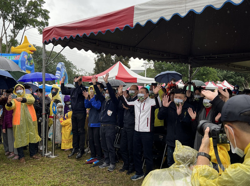 新北市長侯友宜(前排右3)25日上午出席在五股心環原公園舉辦的耶誕節童樂會,跟著台上小朋友一起唱跳律動。中央社記者沈佩瑤攝 110年12月25日