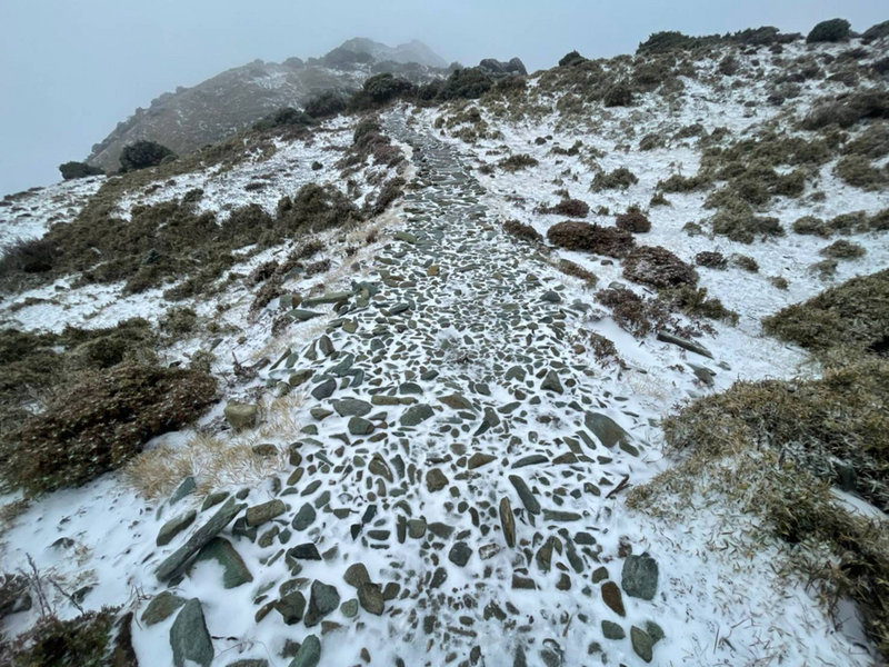 冷氣團發威，海拔3310公尺的嘉明湖山區也下雪霰，步道結冰，山友必須穿冰爪才能行走，否則容易滑倒。（熊出沒戶外休閒服務企業社提供）中央社記者李先鳳傳真 110年12月27日