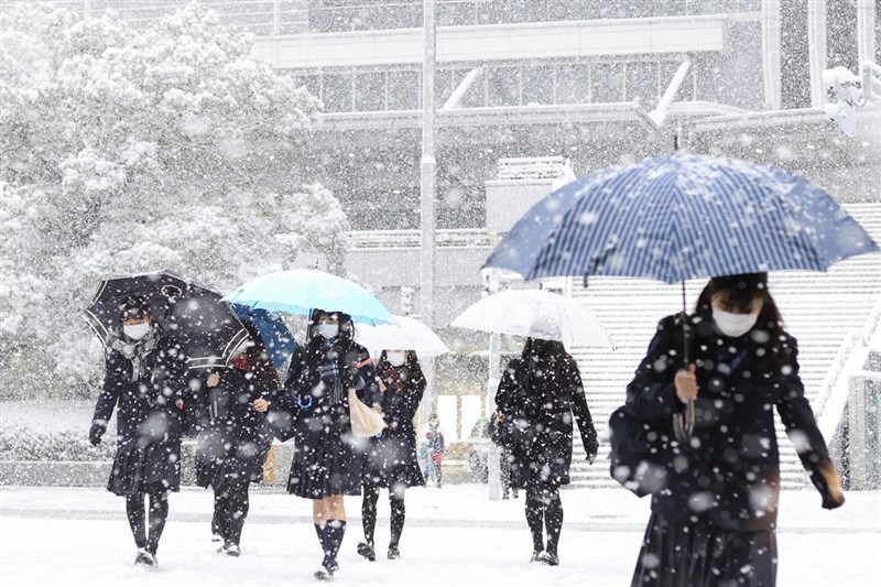 強烈寒流侵襲日本，兵庫縣、滋賀縣降下破紀錄大雪。圖為名古屋車站前行人撐傘在雪中行走。（共同社）