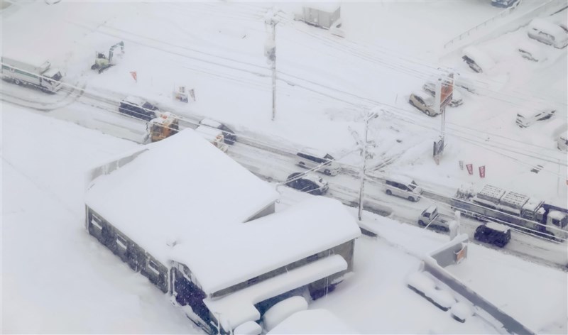 受強烈寒流影響，日本滋賀縣彥根市截至27日上午5時的24小時雪量達68公分，創觀測以來新高紀錄。圖為國道8號滋賀縣彥根市路段車輛因大雪受阻。（共同社）