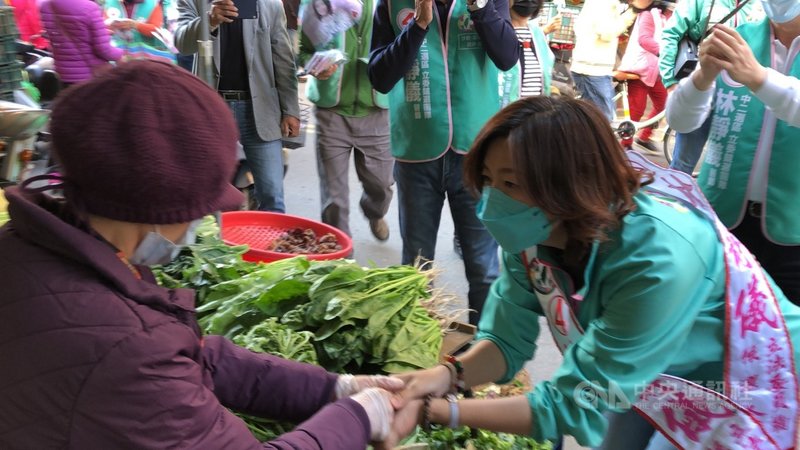 民進黨籍台中市第2選區立委補選參選人林靜儀(右)28日上午到沙鹿市場掃街,向攤商及民眾握手問候,爭取支持。中央社記者趙麗妍傳真 110年12月28日