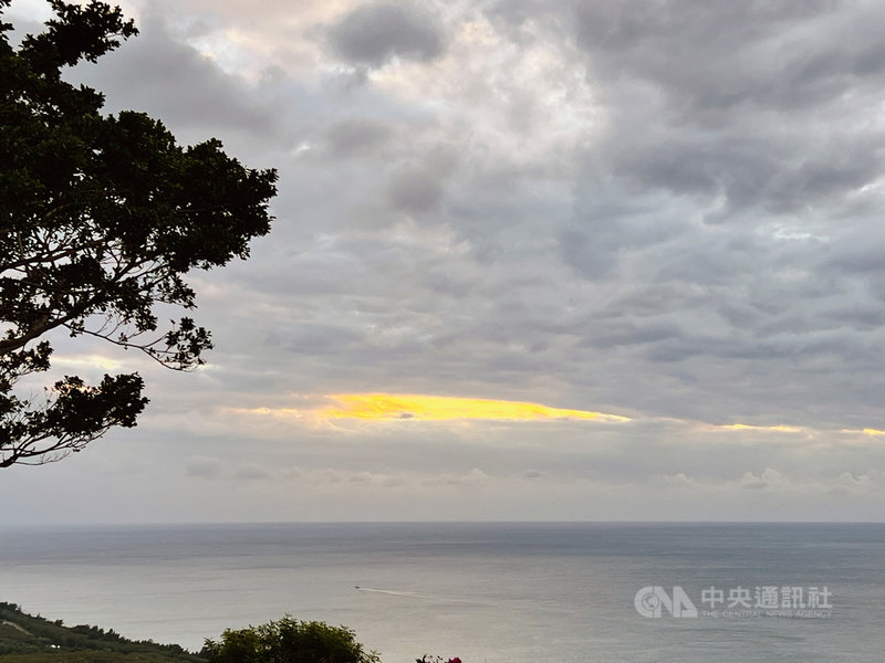 期待2021年最後一次落日,墾丁關山觀景台31日傍晚人潮聚集,可惜天公不作美,空中雲層密布,絕美夕照無緣現身,只能從雲縫中探得些許餘暉。中央社記者李卉婷攝 110年12月31日