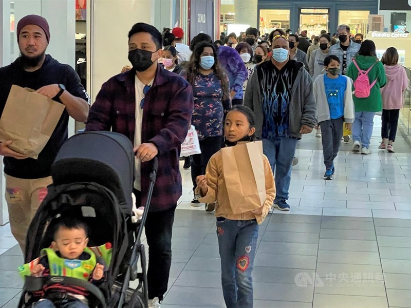 美國衛生專家30日警告,Omicron變異株疫情引發的感染人數創新高勢必影響生活各個層面。圖為耶誕假期美國民眾戴口罩逛百貨公司。(中央社檔案照片)