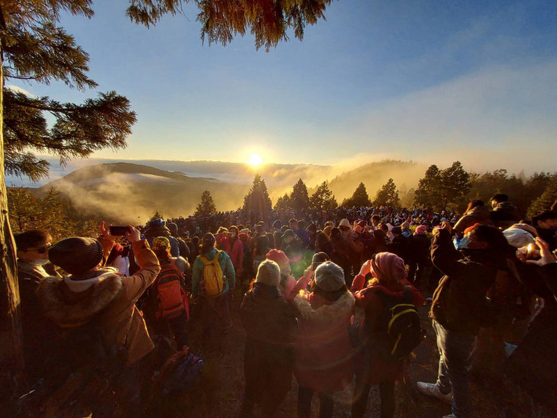 太平山國家森林遊客區1日清晨出現新年日出第一道曙光,3000多名遊客目睹太陽從美麗雲海中冒出的美景,興奮舉起手機,記錄美好一刻。(民眾石世民提供)中央社記者沈如峰宜蘭縣傳真 111年1月1日