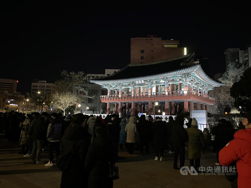 即使跨年敲鐘儀式取消、氣溫降至最低零下10度,仍有許多不畏低溫的民眾來到位於首爾鐘閣十字路口的普信閣前等待跨年倒數。中央社記者廖禹揚首爾攝 111年1月1日
