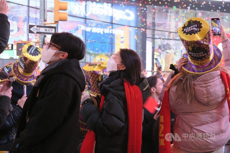 Omicron變異株已影響美國許多經濟活動，新一年恐怕還會令人力短缺和物價上漲惡化。圖為紐約時報廣場跨年活動，多數參加者遵照規定全程佩戴口罩。中央社記者尹俊傑紐約攝 111年1月1日