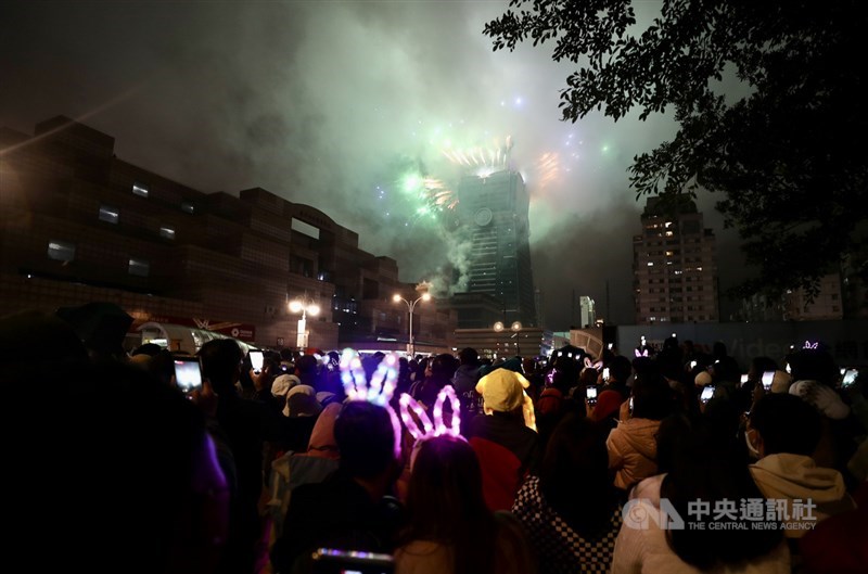 大批民眾12月31日晚間在信義區周邊守候等待台北101一年一度的跨年煙火秀，在倒數結束、煙花綻放瞬間隨即拿出手機記錄搶拍，盼留下美好回憶。中央社記者張皓安攝 111年1月1日