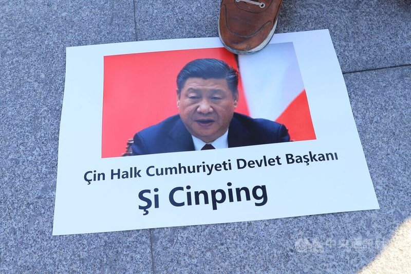 土耳其一個律師團4日向伊斯坦堡檢察長辦公室,對中國國家主席習近平等112名官員在新疆的罪行提起刑事訴訟。一位民眾在記者會後腳踩被告習近平的肖相。中央社記者何宏儒伊斯坦堡攝 111年1月4日