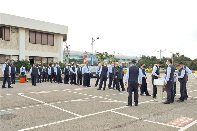 桃園機場防疫車輛停車場1名女清潔員確診，4日上午召回防疫計程車司機篩檢，司機們排隊領取篩檢空瓶等器具，相關採檢作業中午已完成。中央社記者吳睿騏桃園機場攝 111年1月4日