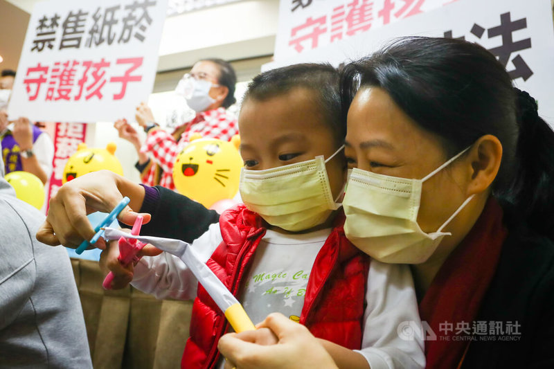 台北市家長志工教育成長協會等社福團體5日舉行記者會,為拒絕菸害呼籲政府盡速修法,全面禁售紙菸,有家長帶著孩子出席表支持,並在記者會上攜手剪斷道具紙菸,象徵拒絕菸害。中央社記者王騰毅攝 111年1月5日