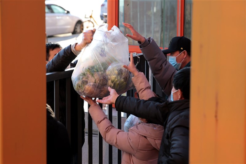 中國獨立媒體人江雪發表紀錄西安封城的「長安十日」一文引發國際關注後，8日在中國網路遭全面下架。圖為去年12月29日西安居民領取蔬菜等物資。（中新社）