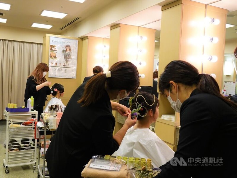 今年1月10日是日本成人節，有些女孩為出席成年儀式，一早就到美容院做造型。圖為「山野愛子美容室」員工為顧客做造型。中央社記者楊明珠東京攝  111年1月10日