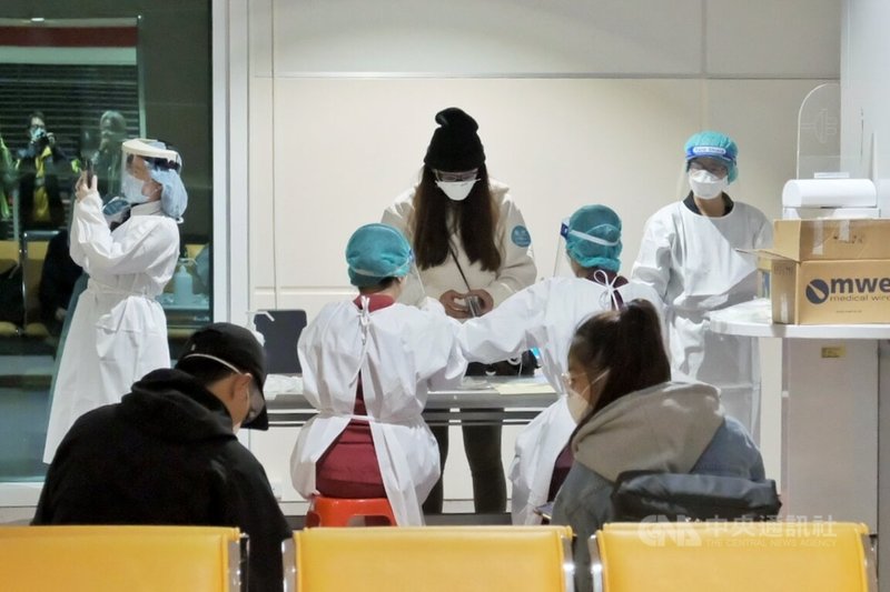 長程航班旅客11日起將進行快速PCR落地採檢,結果為陰性才放行入境;旅客在下機後進入候機室依序坐好,再排隊審核資料並領取採檢用物,隨後前往採檢區進行落地公費採檢及快速核酸檢驗,完成採檢作業後再回到座位上等待結果出爐。中央社記者吳睿騏桃園機場攝 111年1月11日