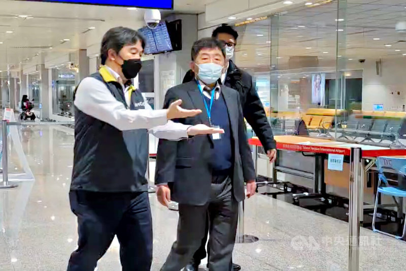 中央流行疫情指揮中心指揮官陳時中(中)12日晚間在桃園國際機場前進指揮所指揮官王必勝(左)陪同下,再度到桃機檢體篩檢站了解作業情況,隨後並視察聯合航空公司UA-871航班旅客採檢作業,以及電信公司於機場販售電話網卡情形。中央社記者吳睿騏桃園機場攝 111年1月12日