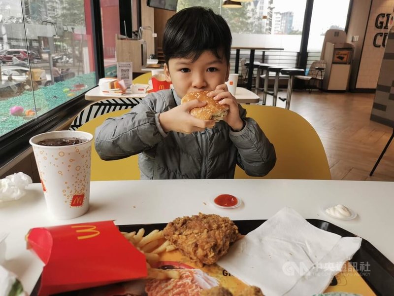 越南傳統以米、麵食為主,口味也相對清淡,但近年來西方速食店將眼光瞄準這個高速成長的經濟體,越南年輕一代對於漢堡、薯條的接受度大幅提升。圖為正在吃漢堡的越南孩童。中央社記者陳家倫河內攝 111年1月13日