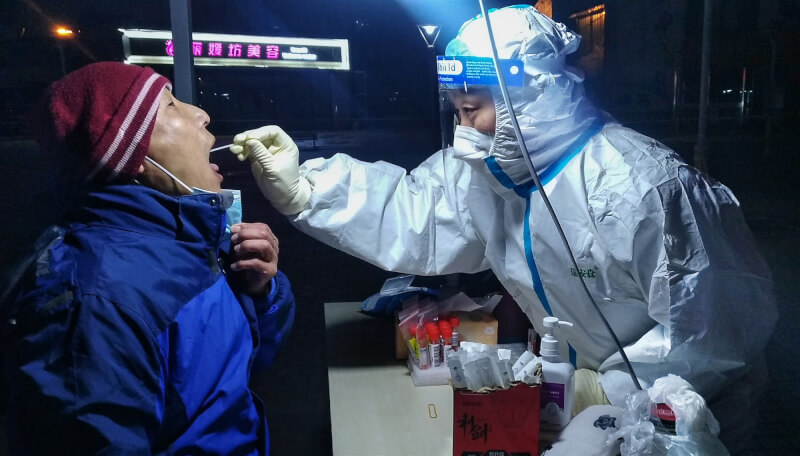 天津實施「軟封城」阻止Omicron疫情擴散,台灣前衛生署長涂醒哲分析,天津可能已有高達500例Omicron確診病例。圖為天津一處採檢站。(中新社)