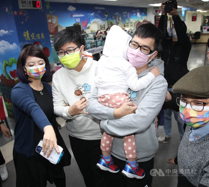 全台第一對同志無血緣收養家庭登記記者會13日在台北市信義區戶政事務所舉行,同志配偶圍圍(白衣)與喵喵(灰衣)帶著小孩肉肉一同前來辦理收養登記。中央社記者張新偉攝 111年1月13日