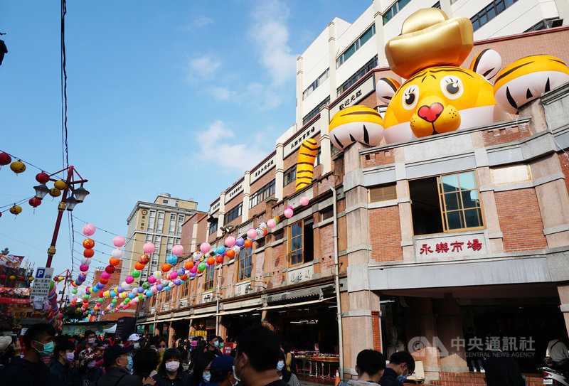 農曆春節腳步近,台北迪化商圈年貨大街15日熱鬧開跑,將持續至30日小年夜,商圈內以年味擺設妝點,營造過年氣氛,永樂市場更設置大型氣球裝置招財福虎及彩繪燈籠等。中央社記者劉建邦攝 111年1月15日