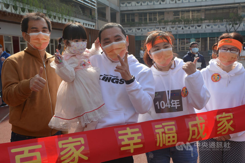 新北市政府15日在板橋埔墘公共托育中心操場舉行7處公共托育中心聯合開幕儀式,市長侯友宜(前右3)率領公托中心主任、老師一起衝向紅色綵帶,並與孩童一起開心合影。中央社記者黃旭昇新北市攝 111年1月15日