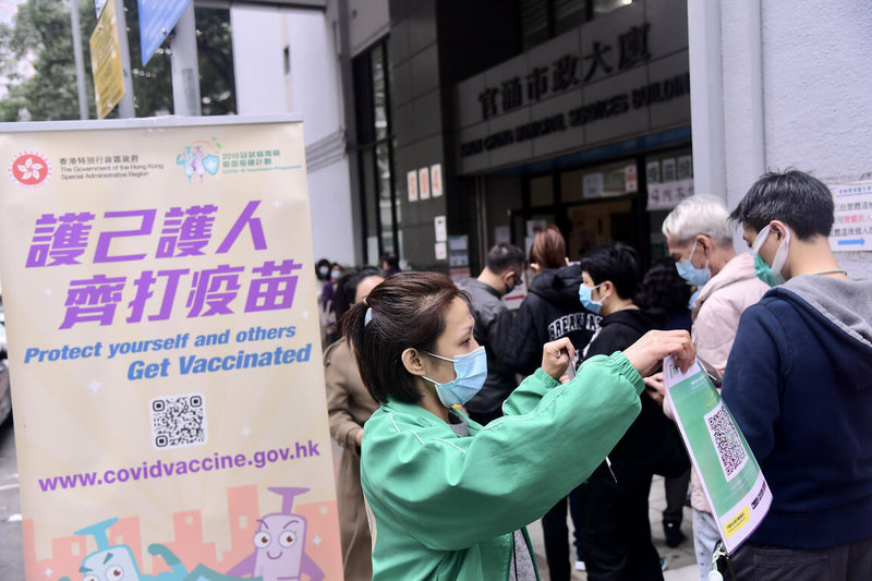 香港官方防疫專家劉宇隆15日表示,社會要與COVID-19病毒共存的大前提是「提高疫苗接種率」。圖為14日,香港官湧體育館的社區疫苗接種中心,大批市民排隊接種疫苗。(中通社提供)中央社 111年1月15日