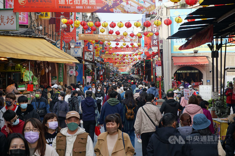 「2022台北年貨大街」15日起正式開跑,今年以「想.享.饗過年」為主題,台北市商業處指出,配合防疫,迪化商圈年貨大街不搭棚架、不提供試吃,由在地商家擺攤,活動首日現場人潮不少。中央社記者劉建邦攝 111年1月15日