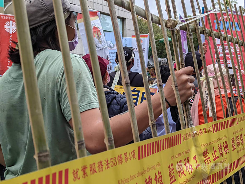 台灣移工聯盟16日在台北舉辦移工大遊行,遊行尾聲,眾人在勞動部門口架起竹柵欄,象徵自由轉換雇主權益遭剝奪;活動最後更一同推倒柵欄,期望禁令能夠解除。中央社記者張雄風攝 111年1月16日