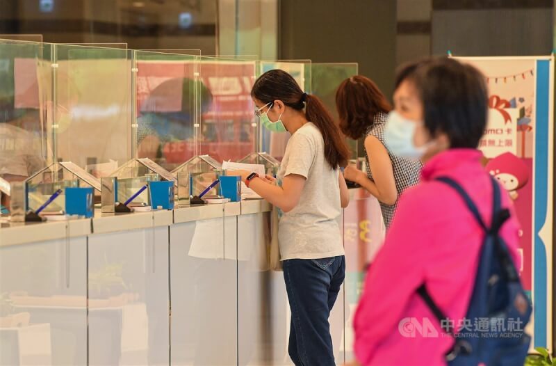 桃園聯邦銀行行員染疫事件,引發外界憂心開戶脫口罩驗證身分程序可能成為防疫破口。圖為民眾戴好口罩到銀行辦事。(中央社檔案照片)